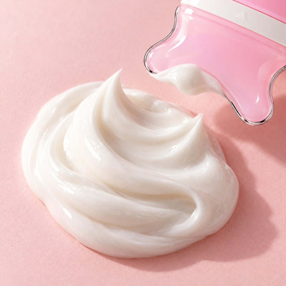 A swirl of white cream on a blush surface